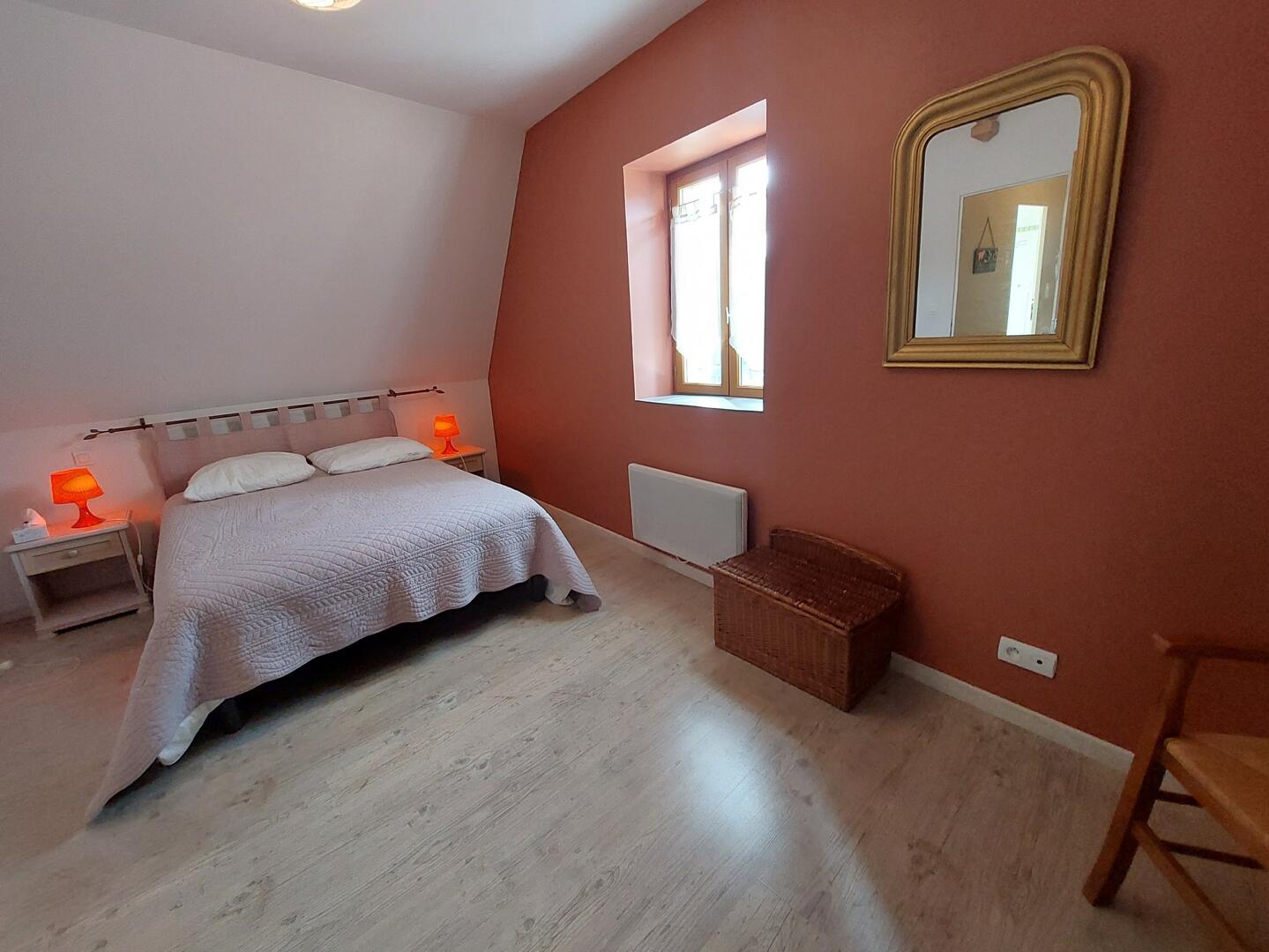 Chambre parentale terracotta avec grand lit double, miroir doré, gîte Sarlat Dordogne