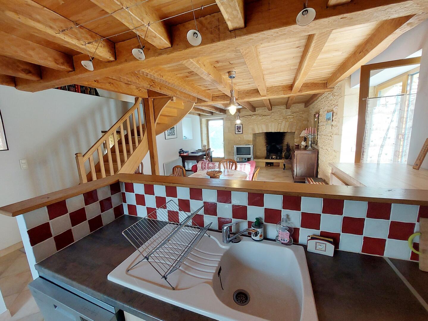 Cuisine équipée vue de profil, carrelage rouge et blanc, gîte Périgord
