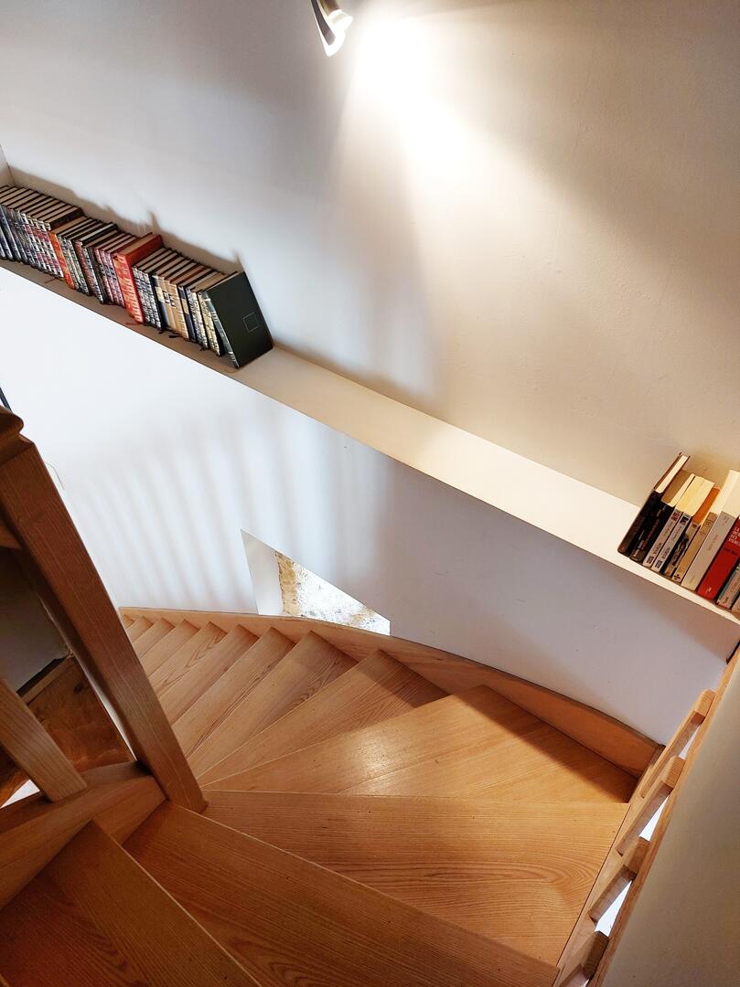 Escalier en bois clair avec bibliothèque intégrée, gîte en Dordogne