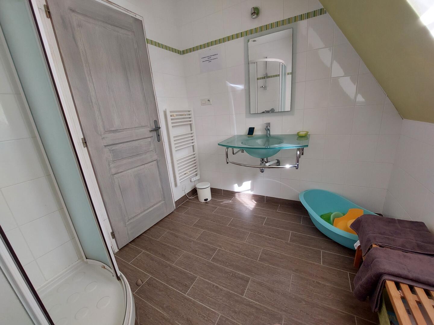 Salle de bain moderne avec vasque en verre, douche et sèche-serviettes, gîte Sarlat